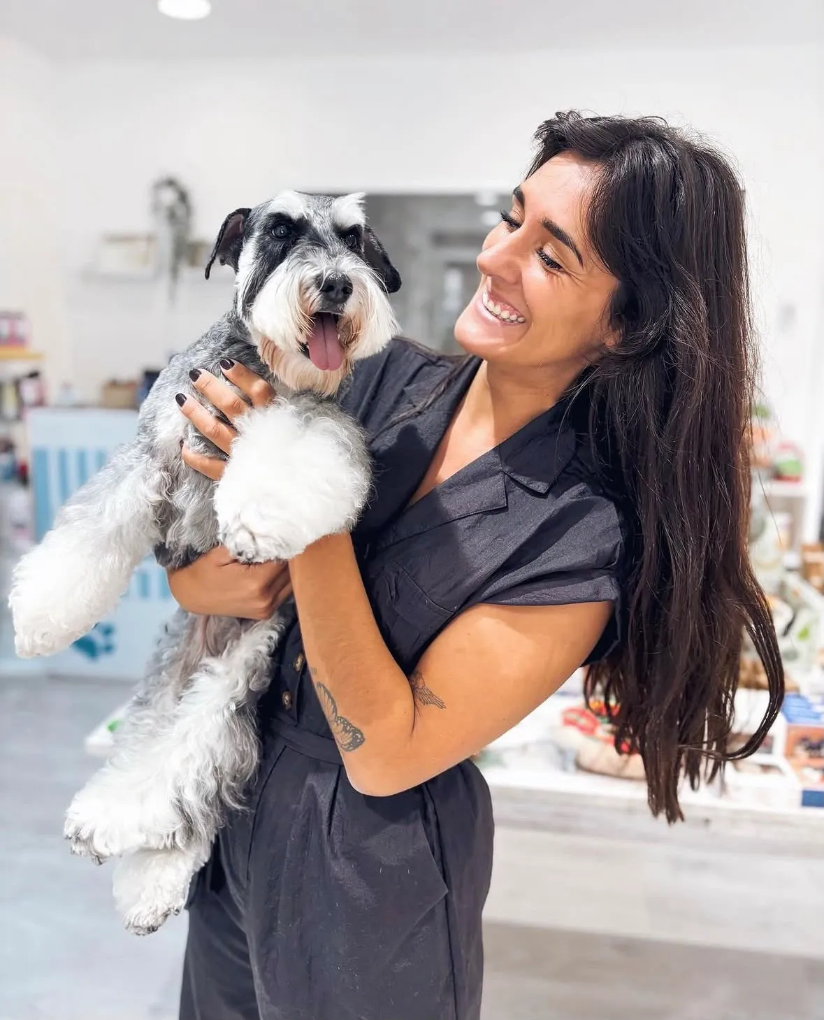 Nerea riendo con un schnauzer gris en brazos